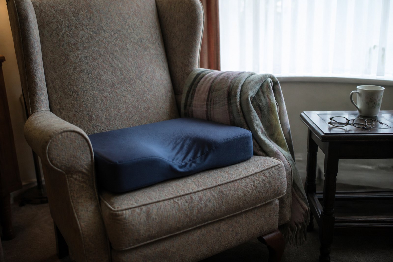 A fireside armchair with a contoured pressure relief cushion on the seat