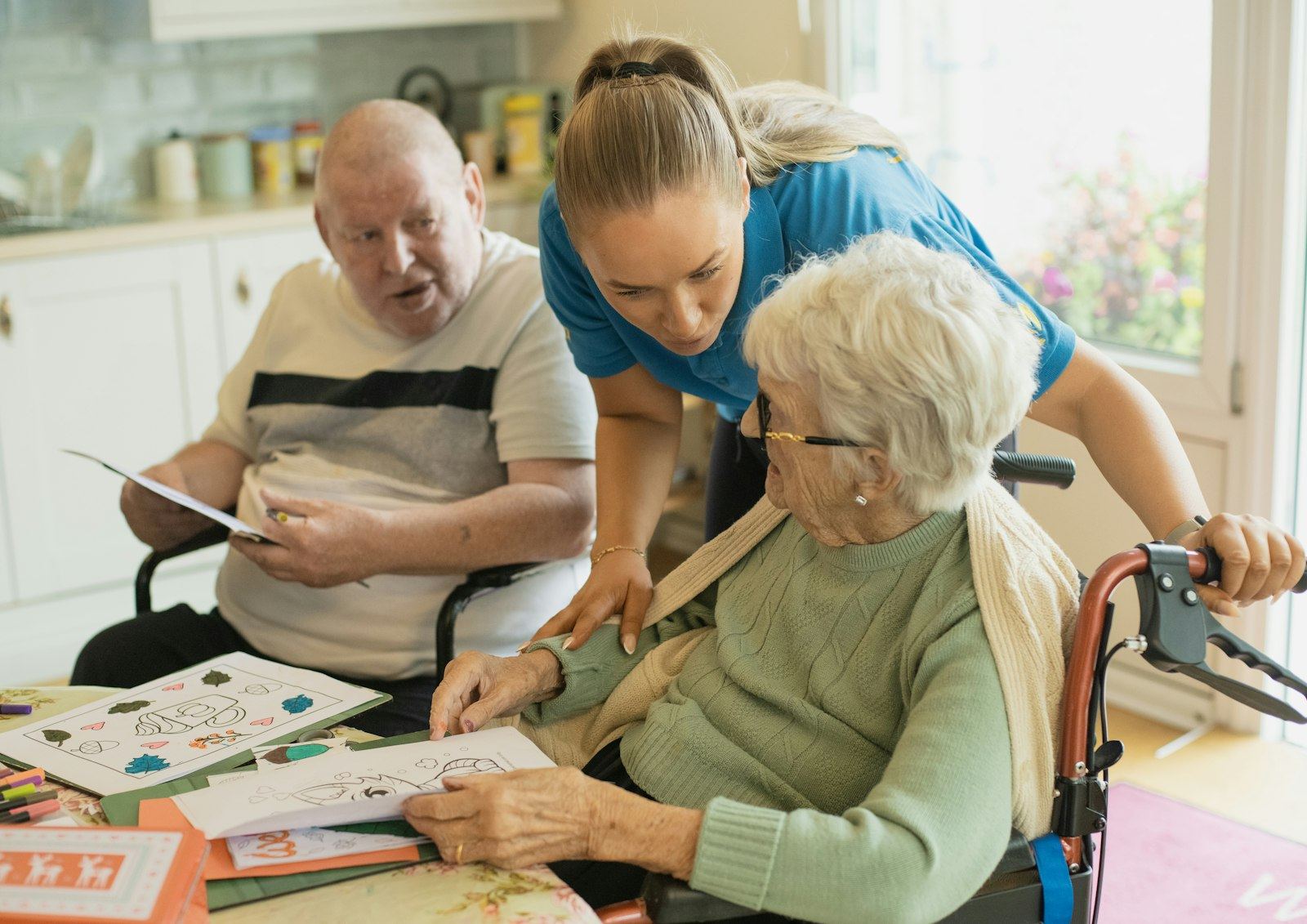 Support worker helping an older couple with a table-top activity
