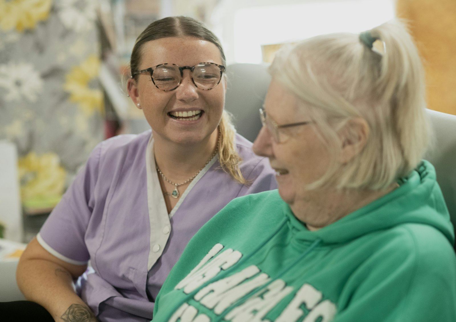 Two women laughing together indoors