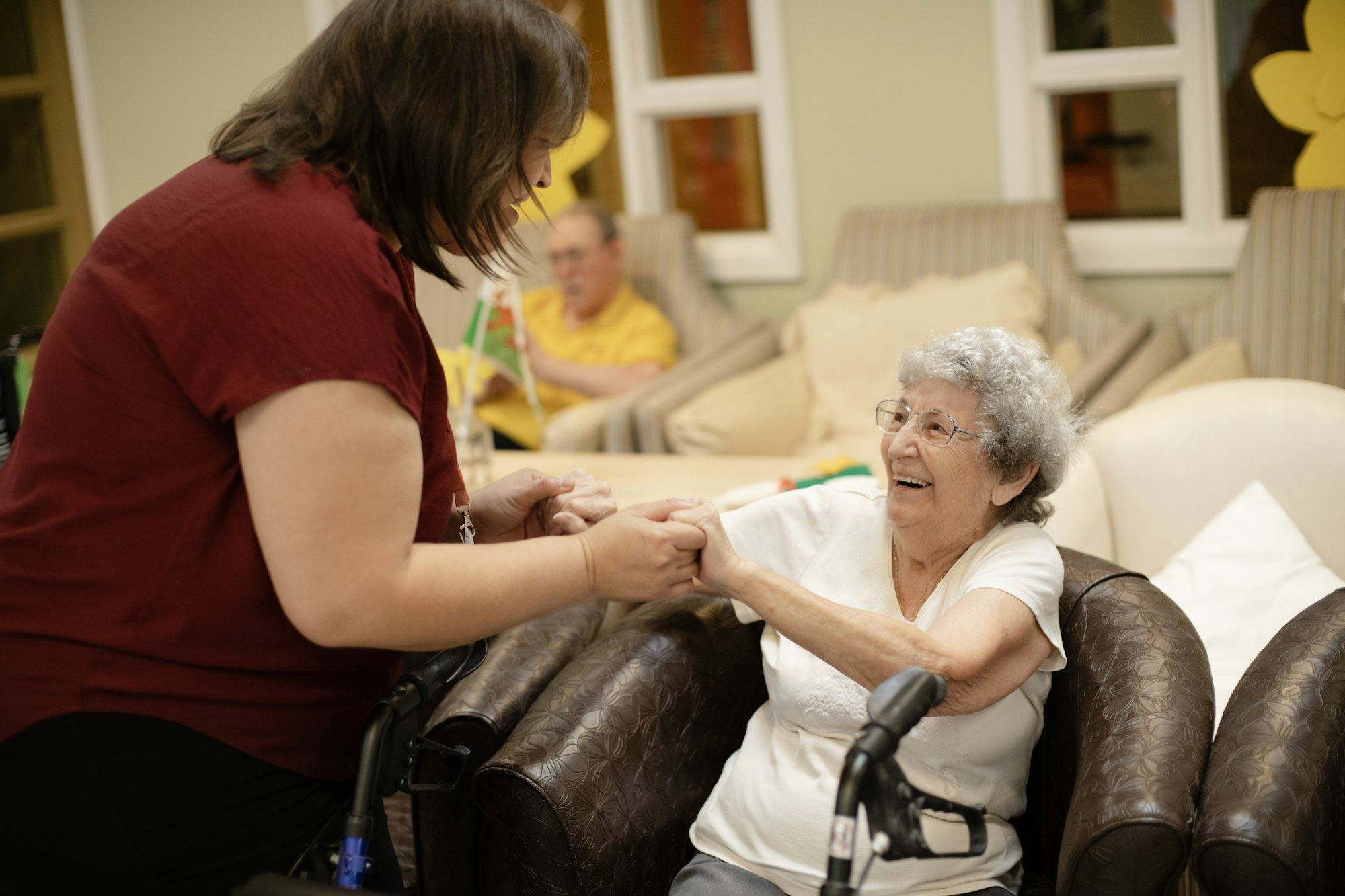 Caregiver supporting an older woman using a walking frame at home