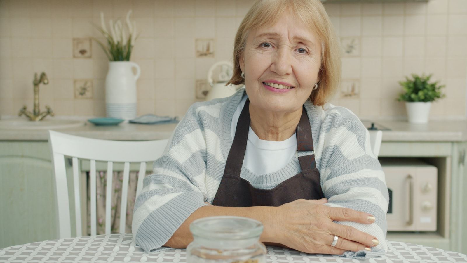 Older woman sitting comfortably at her kitchen table