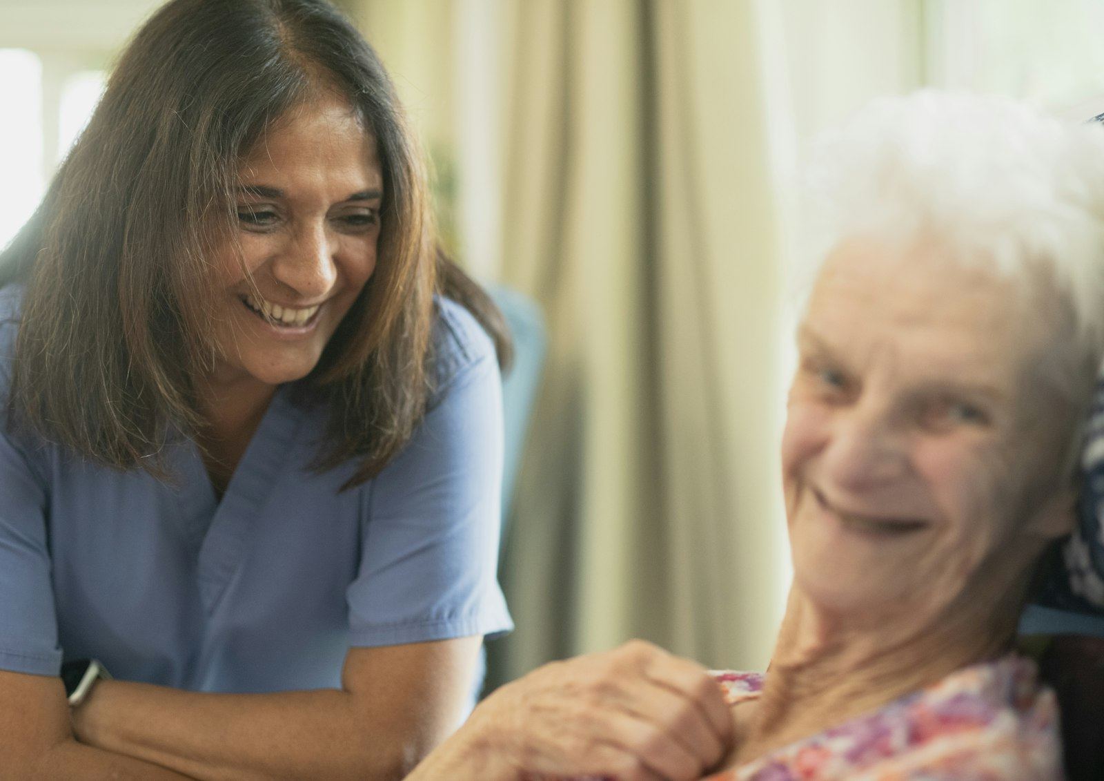 Clinician smiling with an older patient at home